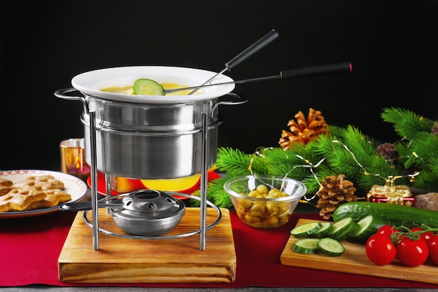Cheese fondue and fresh vegetables on table