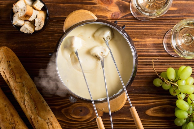 Photo cheese fondue with bread wine and grape swiss winter food