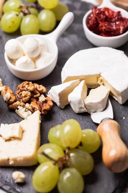 Cheese and grape and nuts on a slate board