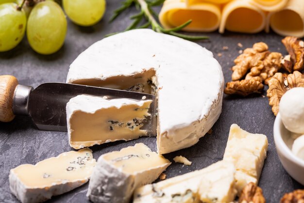 Cheese and grape and nuts on a slate board