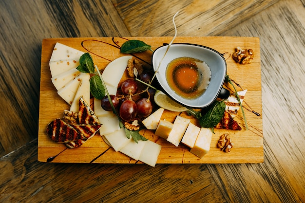 Cheese and grape on the wooden table.