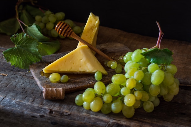 Cheese and grapes on a wood with nuts, honey. French cheese. Breakfast concept. Still life