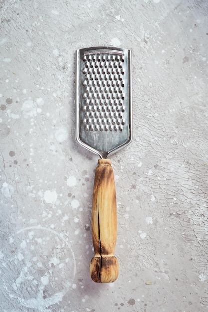 Cheese grater on a stone background. Kitchen utensils. Free space for text.