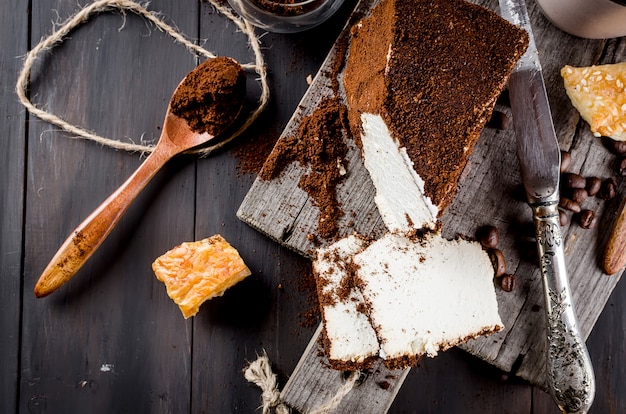 Formaggio nel caffè macinato e una tazza di cappuccino