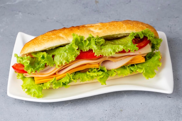 Cheese, ham, lettuce and tomato slices in an appetizing tasty sandwich