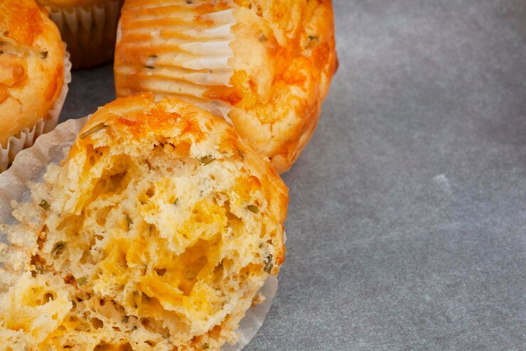Photo チーズとハーブの美味しいマフィンが チーズが完璧に作られ 斑点のある灰色の表面に焼かれています