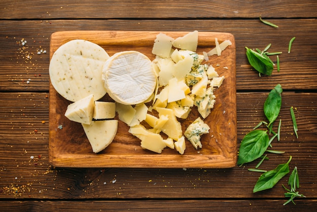 Cheese and herb on wooden table closeup, top view