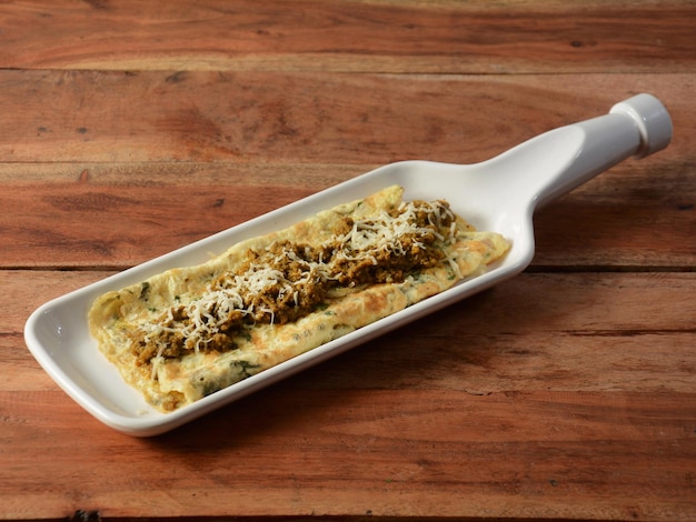 Cheese kheema egg Omelet made with fresh vegetables tomatoonion hot chili pepper parsley served in rustic wooden background selective focus