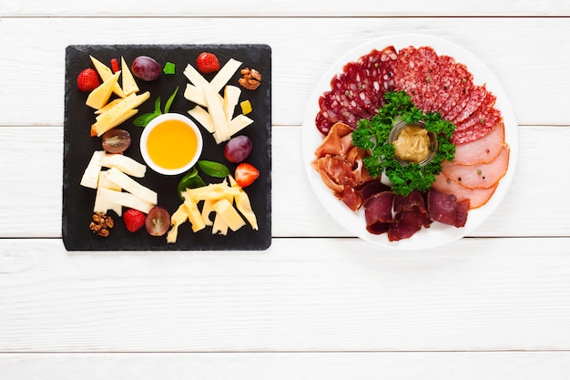 Cheese and meat plates on table