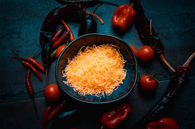 Cheese for mexican food with peppers and cherry tomatoes on darkfood