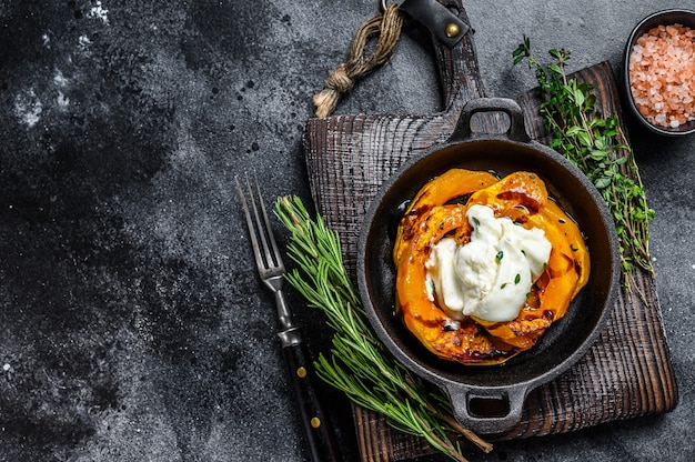 Cheese mozzarella Burrata and baked pumpkin salad. Black background. Top view. Copy space.