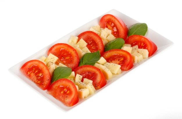 Cheese mozzarella with vegetables in the plate isolated on white