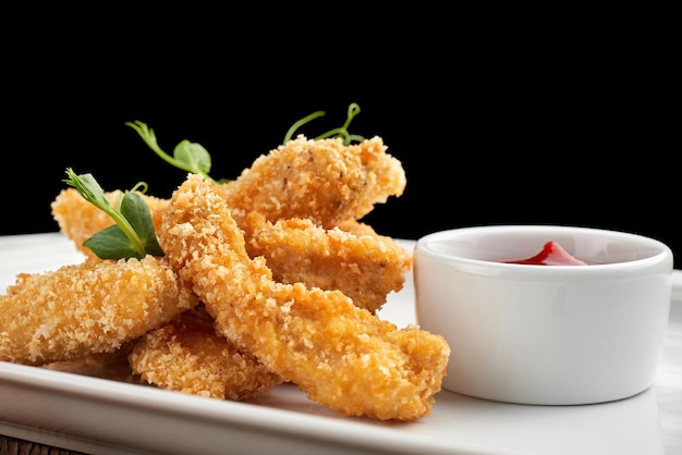 Photo cheese nuggets with sauce on a white plate closeup