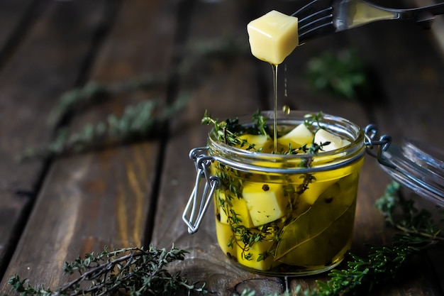 Photo cheese in olive oil with aromatic herbs (thyme and rosemary).