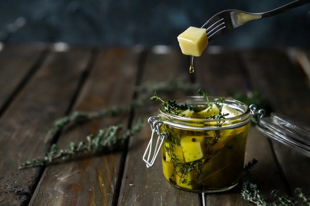 Photo cheese in olive oil with aromatic herbs (thyme and rosemary).