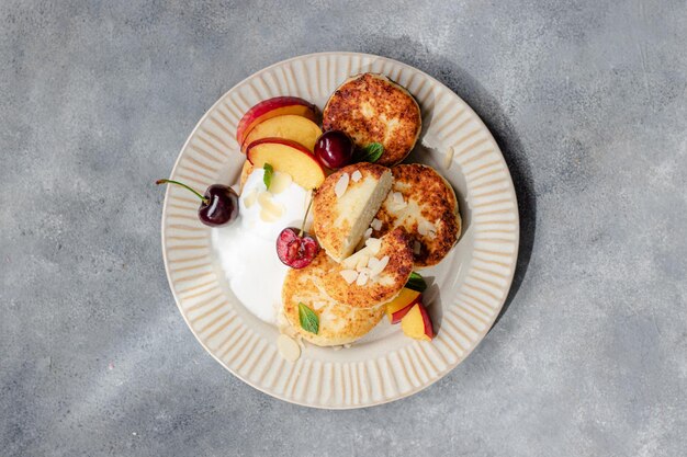 Cheese pancakes with cherry, nectarine, yougurt.  breakfast table