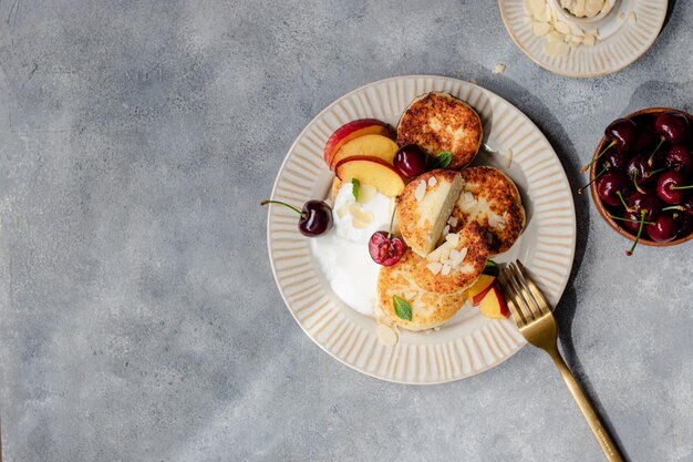 Cheese pancakes with cherry, nectarine, yougurt.  breakfast table