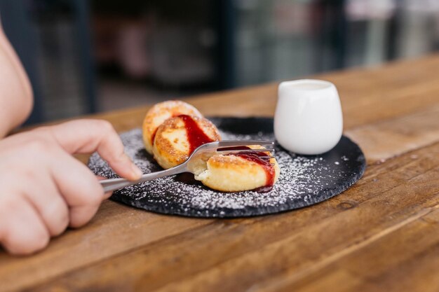 Cheese pancakes with a cup homemade traditional Ukrainian and Russian matches selective focus Cheesecakes on a plate Cheese pancakes or cheesecakes with berry jam