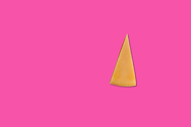 फोटो cheese piece in creative conceptual top view flat lay composition with copy space isolated on pink background in minimal style