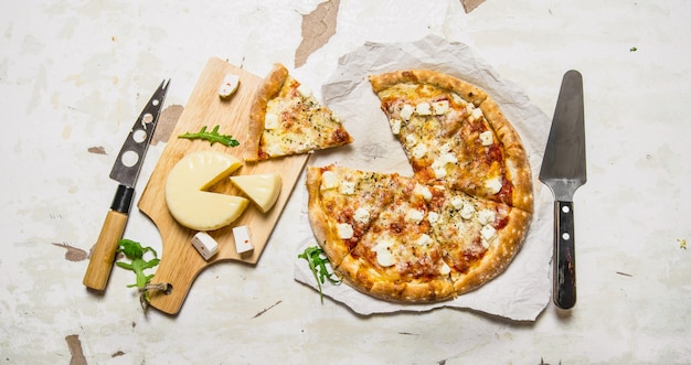 Cheese pizza with herbs and fresh cheese. On rustic background. Top view