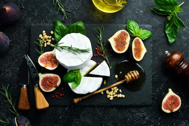 Cheese plate Brie cheese fresh figs and honey on stone board Space for text Top view