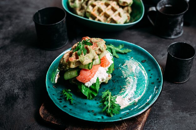 Piatto di formaggi su uno sfondo scuro brie dor blue gouda uve dadi vino