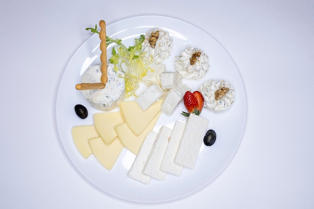 写真 チーズプレートさまざまな種類のチーズを使った料理パルメザンソフトチーズスイスチーズレストランメニュークルミのイチゴ白い背景の料理