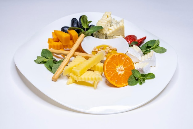 Cheese plate Emmental Camembert cheese blue cheese bread sticks walnuts hazelnuts honey grapes Place for text White background Copy space Restaurant menu Snack for wine