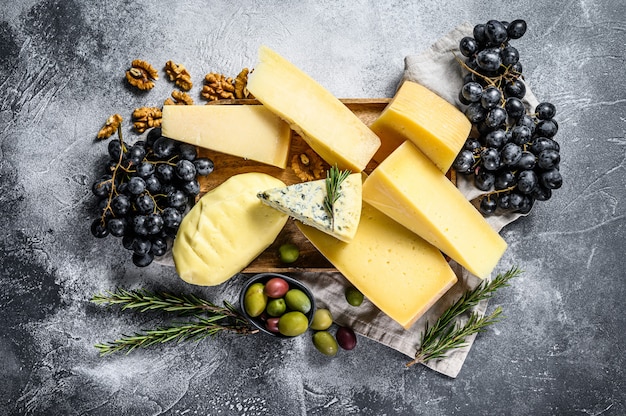 Cheese plate served with grapes, crackers, olives and nuts. Assorted delicious snacks. Top view