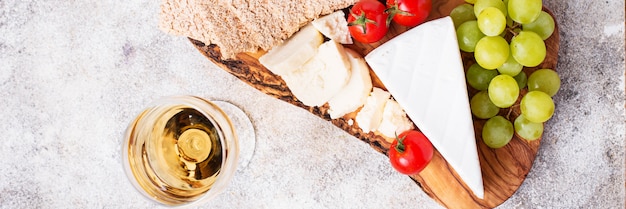 Cheese plate with brie, grape and wine