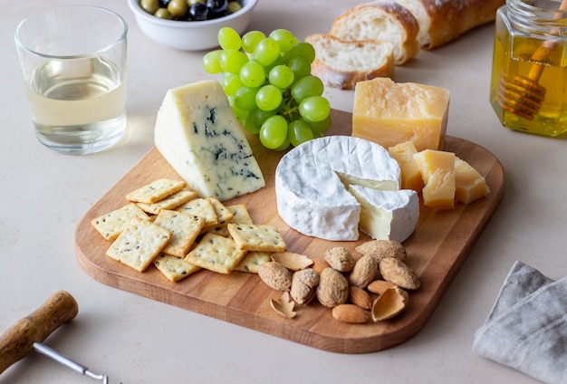 Cheese plate with cracker, almonds and grapes
