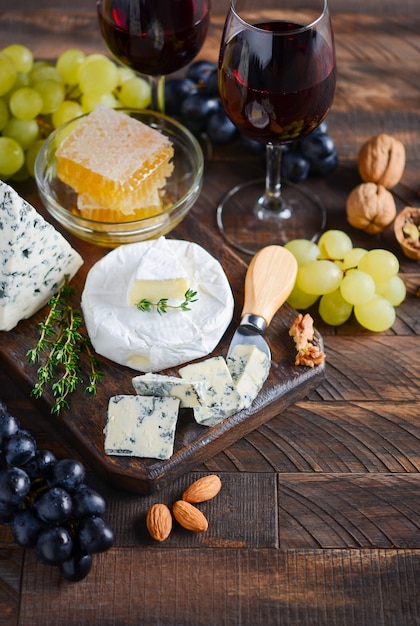 Cheese plate with grapes, honey, nuts and red wine