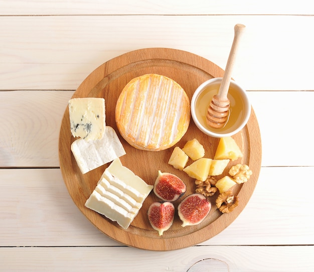 Cheese plate  with various types of cheese, honey and figs 