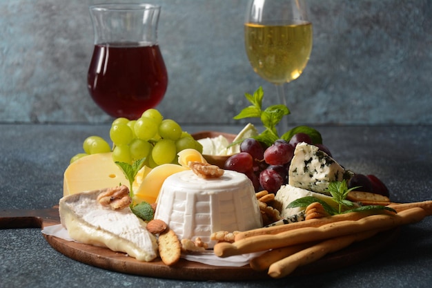 Cheese platter with assorted cheeses grapes nuts and snacks  Italian French cheese starter