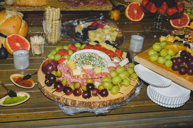 Piatto di formaggi con frutta e salumi durante una festa serale