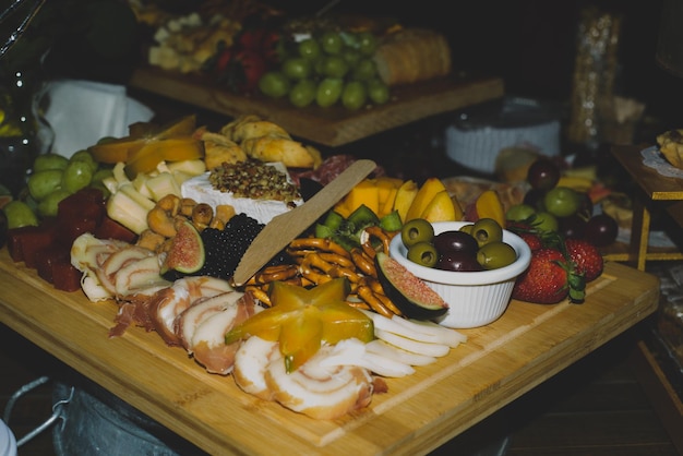 Cheese platter with fruits and cold meats during an evening celebration