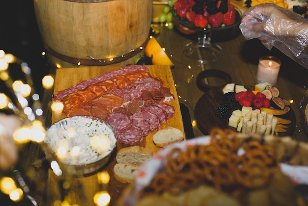 Cheese platter with fruits and cold meats during an evening celebration