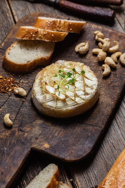 A cheese platter with nuts on a wooden board