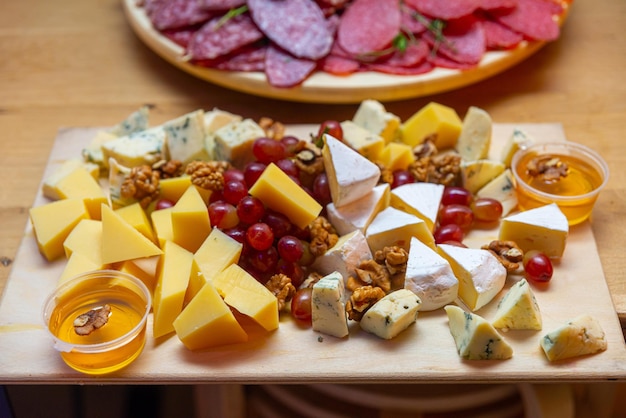 Cheese platter with salami grapes walnuts and honey