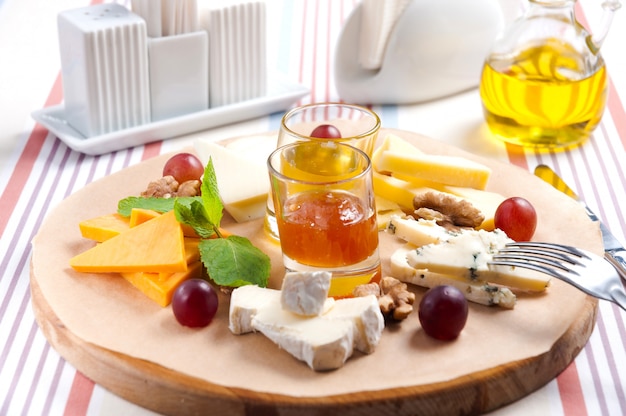 Cheese platter with walnuts, honey and grapes