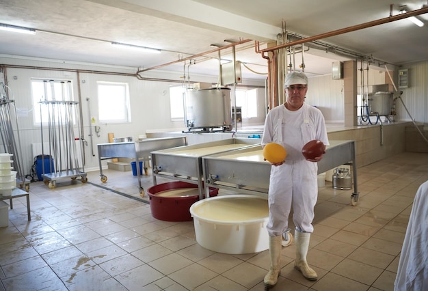 Cheese production male cheesemaker employee working in factory