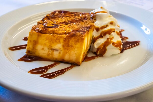 Cheese ramekin or quesada or cheesecake with icecream and chocolate coating on the dish