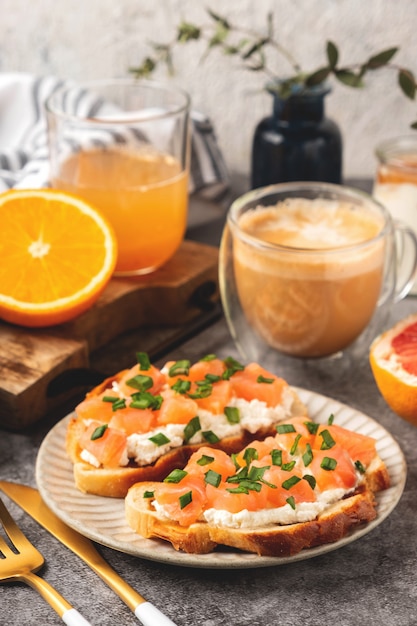 Foto toast di formaggio e salmone, concetto di colazione con caffè e succo d'arancia appena spremuto, cibo sano.