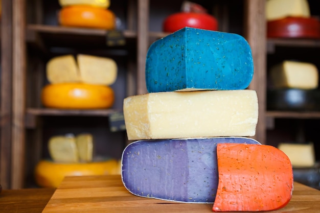Cheese shop assortment. Gouda pesto lavender, blue, violet and red at cheese grocery background