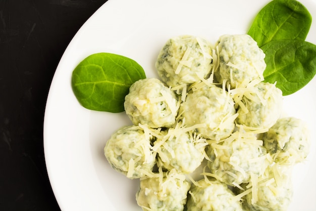 Cheese spinach gnocchi on white plate