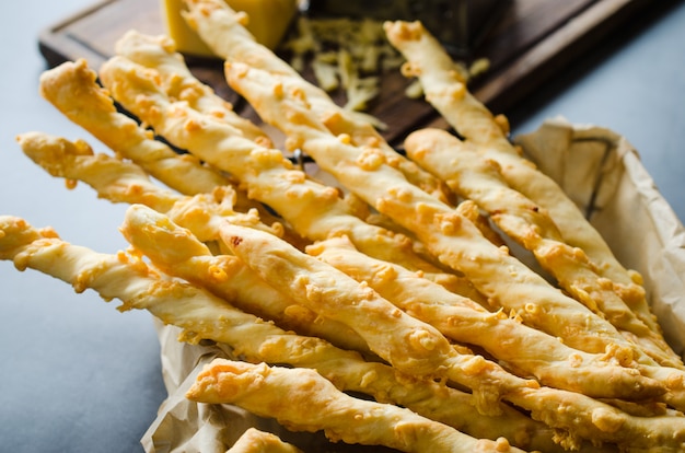 Foto stick di formaggio grissini con formaggio su sfondo scuro. concetto per merenda o tempo di festa