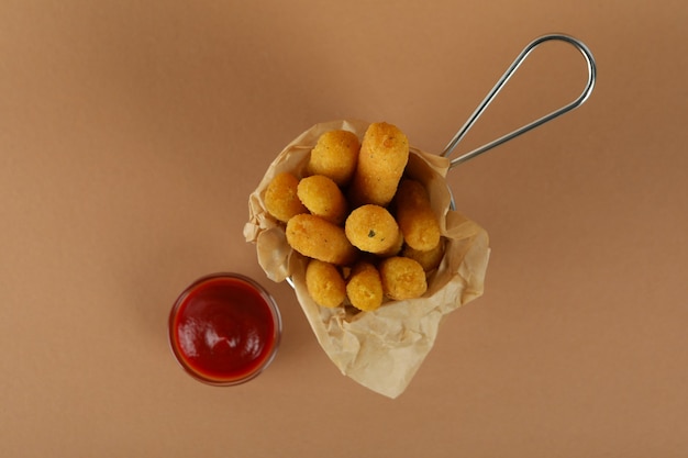 Bastoncini di formaggio e ketchup su sfondo marrone