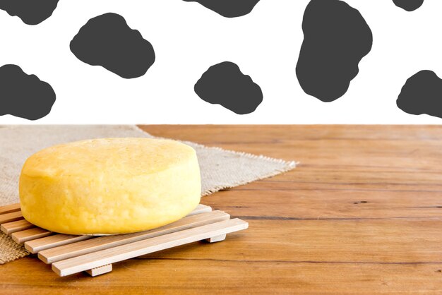 Cheese on table with cow texture background.