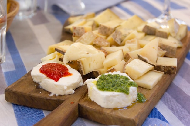 Cheese variety tapas on wooden cutting board. Traditional Spanish snack food, appetizer concepts