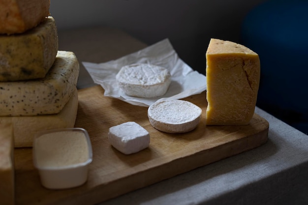 Cheese wheels produce for sale on the counter Fresh cheese loaf selection pile of many cheese